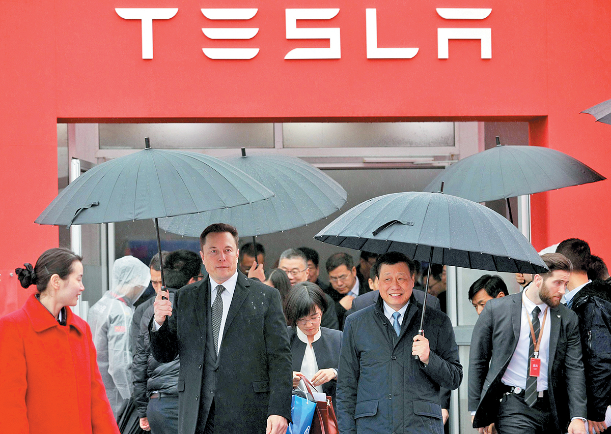 Tesla Chief Executive Officer Elon Musk walks next to Tesla_s Senior Vice President Tom Zhu and Vice President Grace Tao as he leaves a hotel in Beijing_ China May 31_ 2023. copy