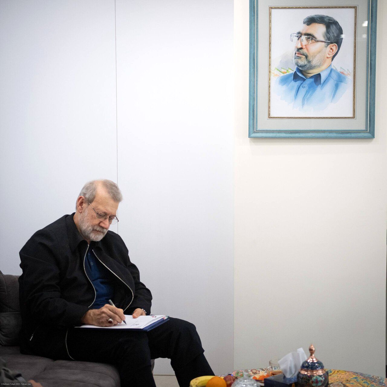 دیدار علی لاریجانی با خانواده شهیدان حاجی‌زاده و محمود باقری/ عکس خاص لاریجانی حین تماشای عکس های سرداران شهید جنگ 12 روزه + تصاویر