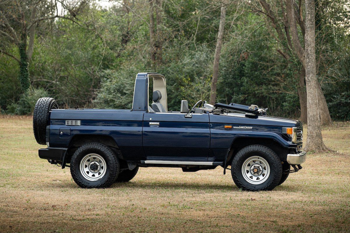 نمای تویوتا لندکروزر سری ۷۰ مدل HZJ73 با بدنه کروک و شیشه جلوی تاشو در فضای باز.